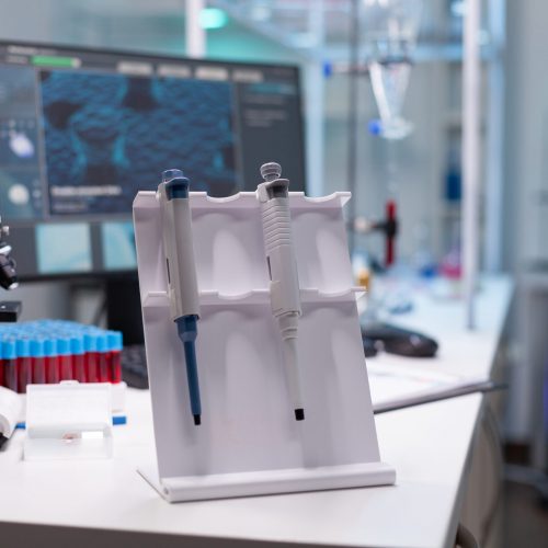 Medical microbiology hospital laboratory equipped with medicine biological micropipette and vacutainer blood sample standing on table during biochemistry experiment. Healthcare investigation